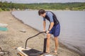 Sports man inflates pump paddle Board, fashionable modern entertainment Royalty Free Stock Photo