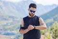 Sports man time smartwatch in outdoor fitness, training exercise time for mountain marathon and tracking heartbeat Royalty Free Stock Photo