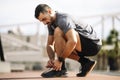 Sports man tying shoe laces in preparation for running training. Handsome young male getting ready to workout. Royalty Free Stock Photo