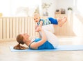 Sports mother is engaged in fitness and yoga with baby at home Royalty Free Stock Photo