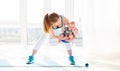 Sports mother is engaged in fitness and yoga with baby at home Royalty Free Stock Photo