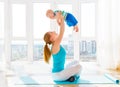 Sports mother is engaged in fitness and yoga with baby at home Royalty Free Stock Photo