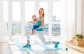 Sports mother is engaged in fitness and yoga with baby at home Royalty Free Stock Photo