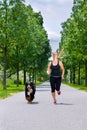 Sports outdoor - young woman running with dog in park Royalty Free Stock Photo