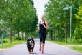 Sports outdoor - young woman running with dog in park Royalty Free Stock Photo