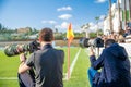 Sports photographers and journalists recorded during the game on the football field