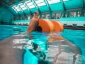 Sports pool with clear, transparent turquoise water. Female legs with dumbbells aqua