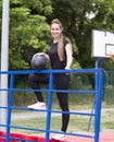 Sports posing of a young fit girl in black clothes and white sneakers. Royalty Free Stock Photo