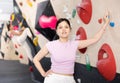 Sports positive woman climber on background of climbing wall