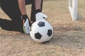 Sports and recreation concept a male teenage goalkeeper wearing black outfit and a pair of colorful gloves holding a soccer