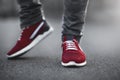 Sports red sneakers close-up on asphalt. Legs and shoes from the lower angle Royalty Free Stock Photo