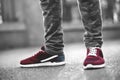 Sports red sneakers close-up on asphalt. Legs and shoes from the lower angle Royalty Free Stock Photo