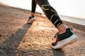 Sports and running. A woman runs along the sea. Close-up of feet in sneakers