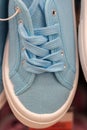 Sports shoes, blue pastel color sneakers on the store counter. vertical