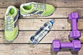 Sports sneakers, dumbbells, drinking water on a wooden background, hdr, flat lay Royalty Free Stock Photo