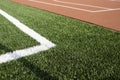 Sports stadium background. Red artificial rubber court ground and white line and green synthetic artificial grass soccer Royalty Free Stock Photo