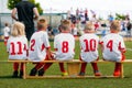 Sports team on the wooden bench during the youth tournament on a sunny summer day