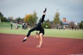 Sports teenage girl in the stadium performs gymnastic exercises