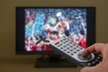 Sports television remote control in the hand, zapping Royalty Free Stock Photo