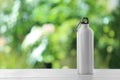 Sports water bottle on table against blurred background