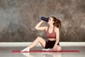 Sports water bottle in woman hand in yoga studio. Royalty Free Stock Photo