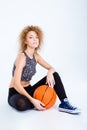 Sports woman sitting on the floor with basketball ball Royalty Free Stock Photo