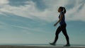 Sports woman walking against a sky background