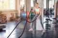 Young woman working out with battle ropes in gym Royalty Free Stock Photo