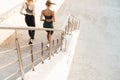 Sports women friends running outdoors by steps Royalty Free Stock Photo