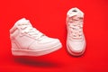 Sports youth shoes on red background close-up. white leather lace-up sneakers