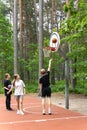 Sports youth in sportswear throws the ball into the basketball hoop in Dzintari Forest Park