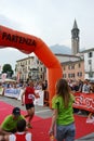 Sportsman arriving at the finish of `Lecco city - Resegone mountain` running marathon event.