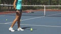 Legs of woman beating tennis racket on ball near net on court Royalty Free Stock Photo