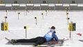 Sportsman biathlete aiming, rifle shooting, reloading rifle in prone position. Biathlete Ageev Danil in shooting range