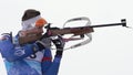 Sportsman biathlete aiming, rifle shooting, reloading rifle in standing position