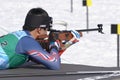 Sportsman biathlete aiming, rifle shooting, reloads in prone position. South Korea biathlete Yang Seon Jik in shooting range.