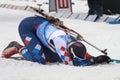 Sportsman biathlete lies on snow, relaxes after rifle shooting, sprint skiing distance and finish. Regional junior