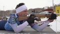 Sportsman biathlete rifle shooting in prone position on biathlon shooting range