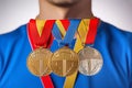 Sportsman holding gold and silver medals on gray background, close-up Royalty Free Stock Photo