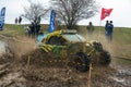 Sportsman on BRP buggy drives splashing in dirt and water at Mud Racing contest. ATV SSV