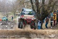 Sportsman on buggy jumps in air splashing with dirt and water at Mud Racing contest. ATV SSV motobike competitions are popular