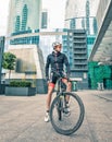 Sportsman cyclist stay with bicycle at street among skyscrapers