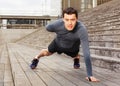 Sportsman doing push-ups on one hand outdoors