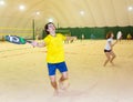 Sportsman hits ball by racket on beach tennis game Royalty Free Stock Photo