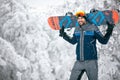 Sportsman holding ski board and return from skiing terrain Royalty Free Stock Photo