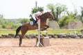Sportsman on horse jumping over a hurdle in the jumping competition, the moment of separation f