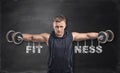 Sportsman lifts dumbbells for training his deltoids. Royalty Free Stock Photo