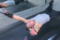 Sportsman making exercises in air uses trainer for myofascial stretching in gym.