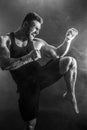 Sportsman muay thai boxer fighting on black background with smoke.