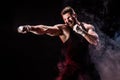 Sportsman muay thai boxer fighting on black background with smoke. Royalty Free Stock Photo